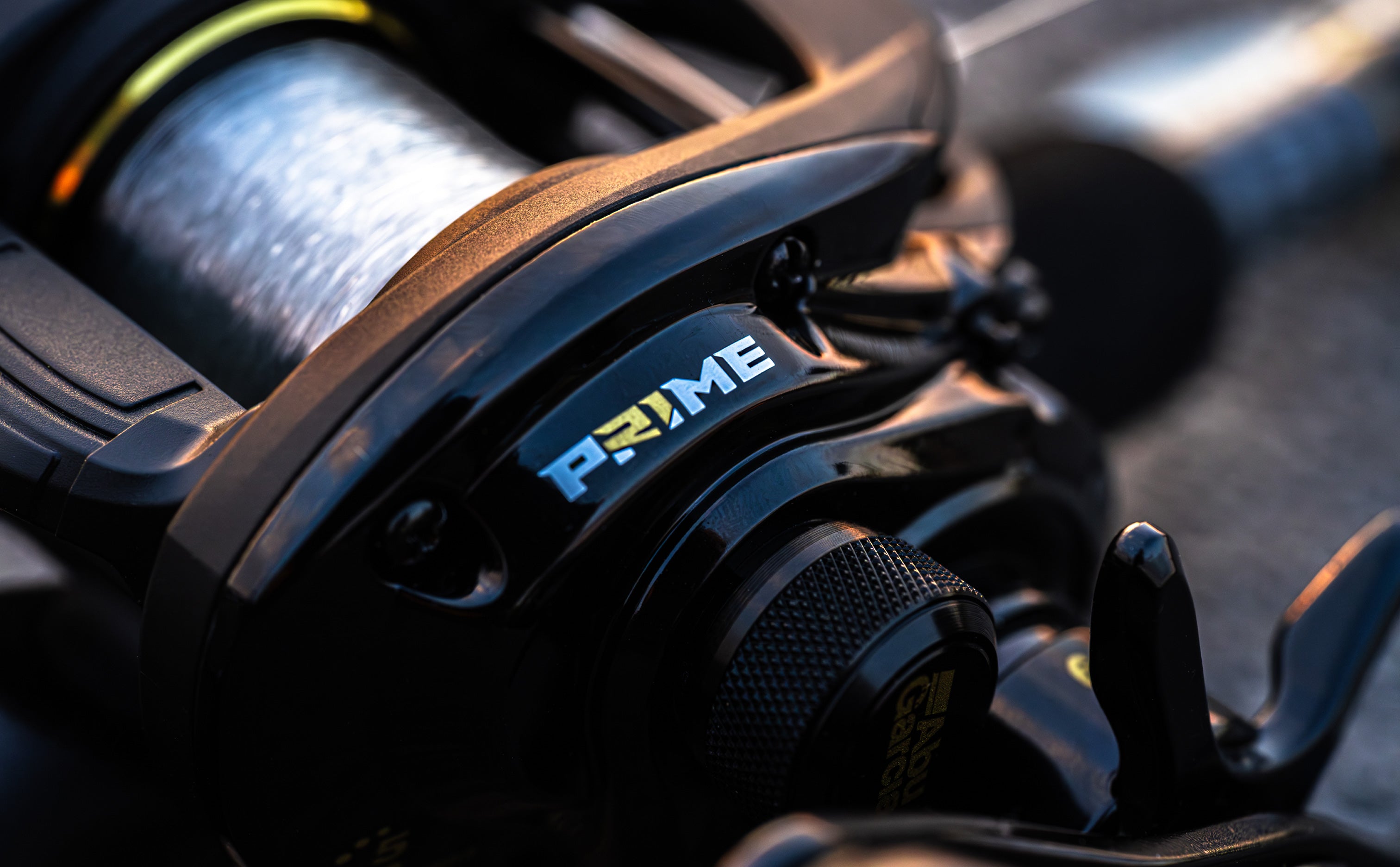 Close-up of a fishing reel with 'Prime' branding on a blurred background