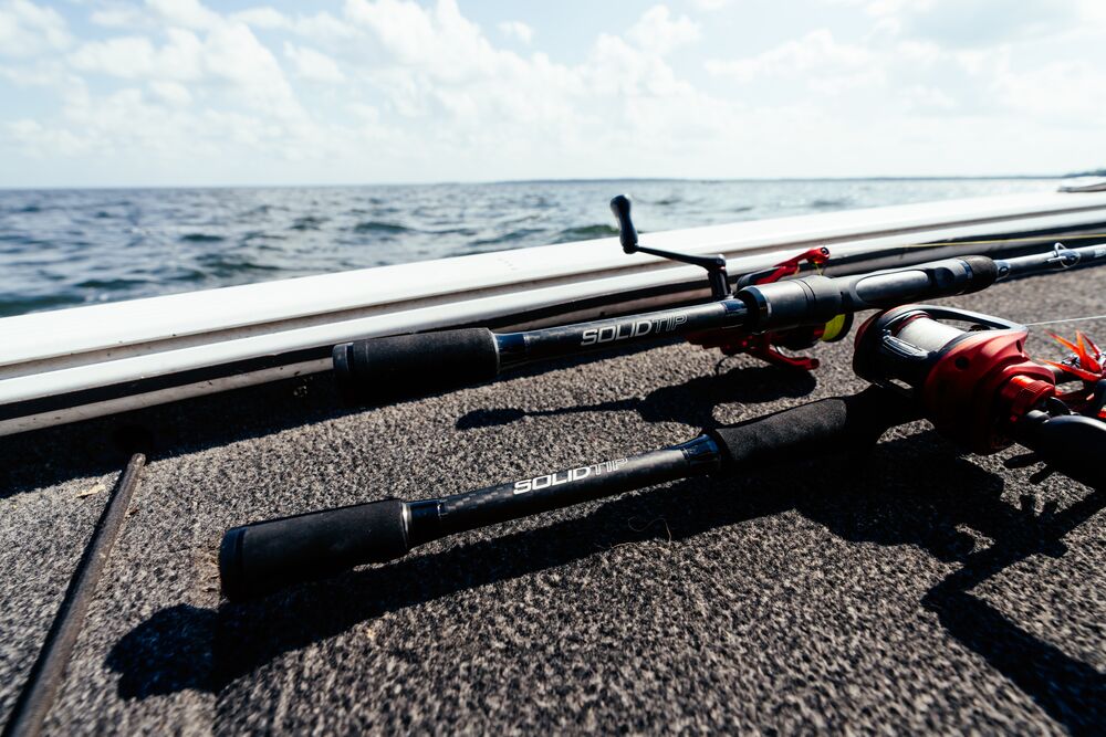 Abu Garcia Veritas Tournament Solid Tip rods laying on pavement with water in background. 